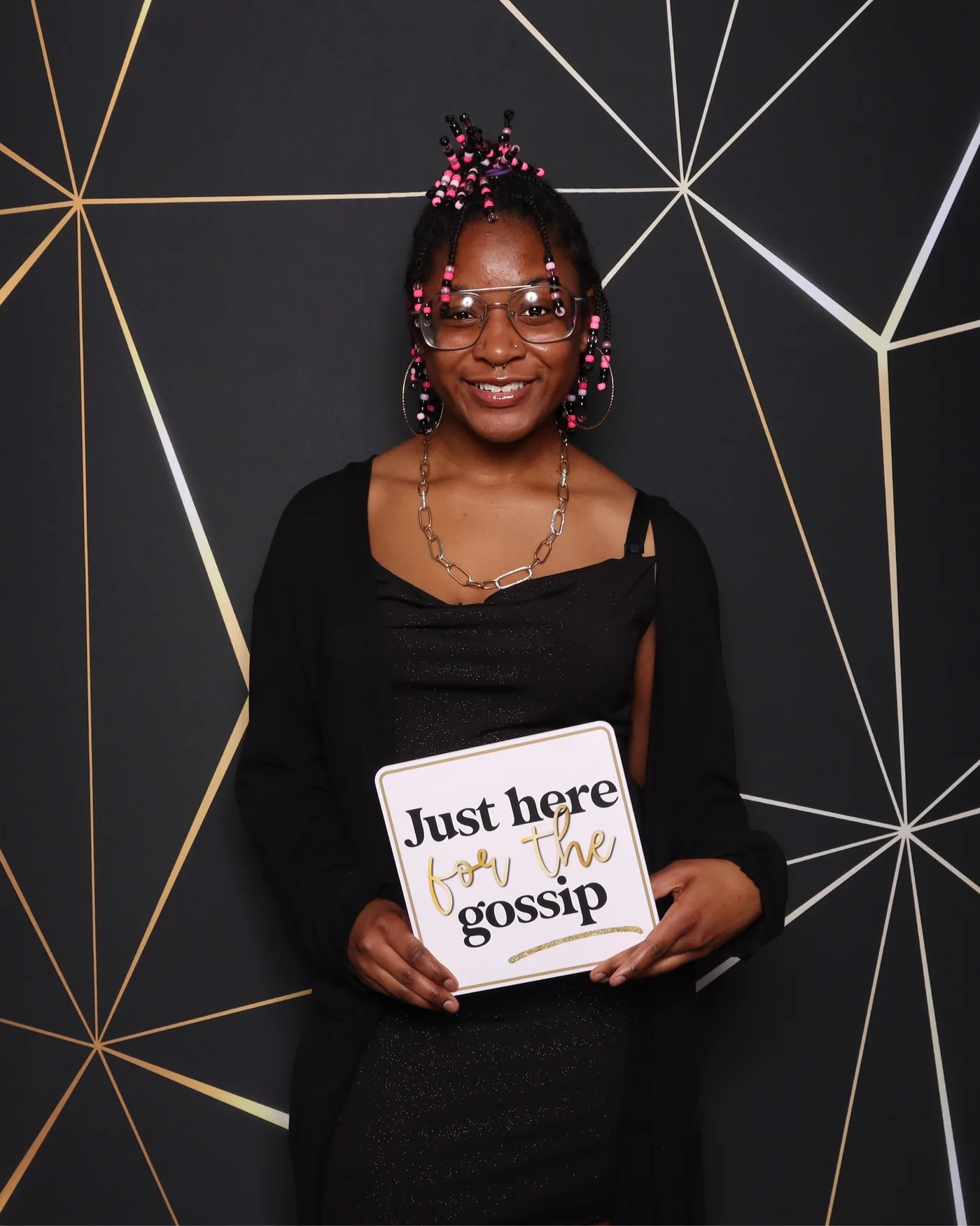 Guest holding a "Just here for the gossip" prop sign at a black and gold photo booth — Virginia Beach