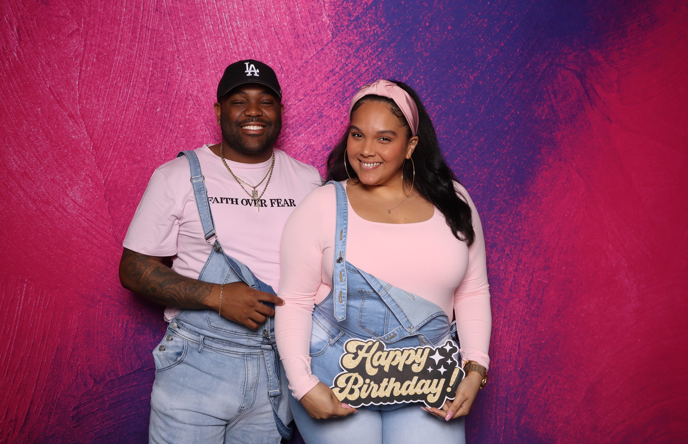 Kapri's first birthday party photo booth Virginia Beach 2025 — couple with Happy Birthday sign and pink backdrop