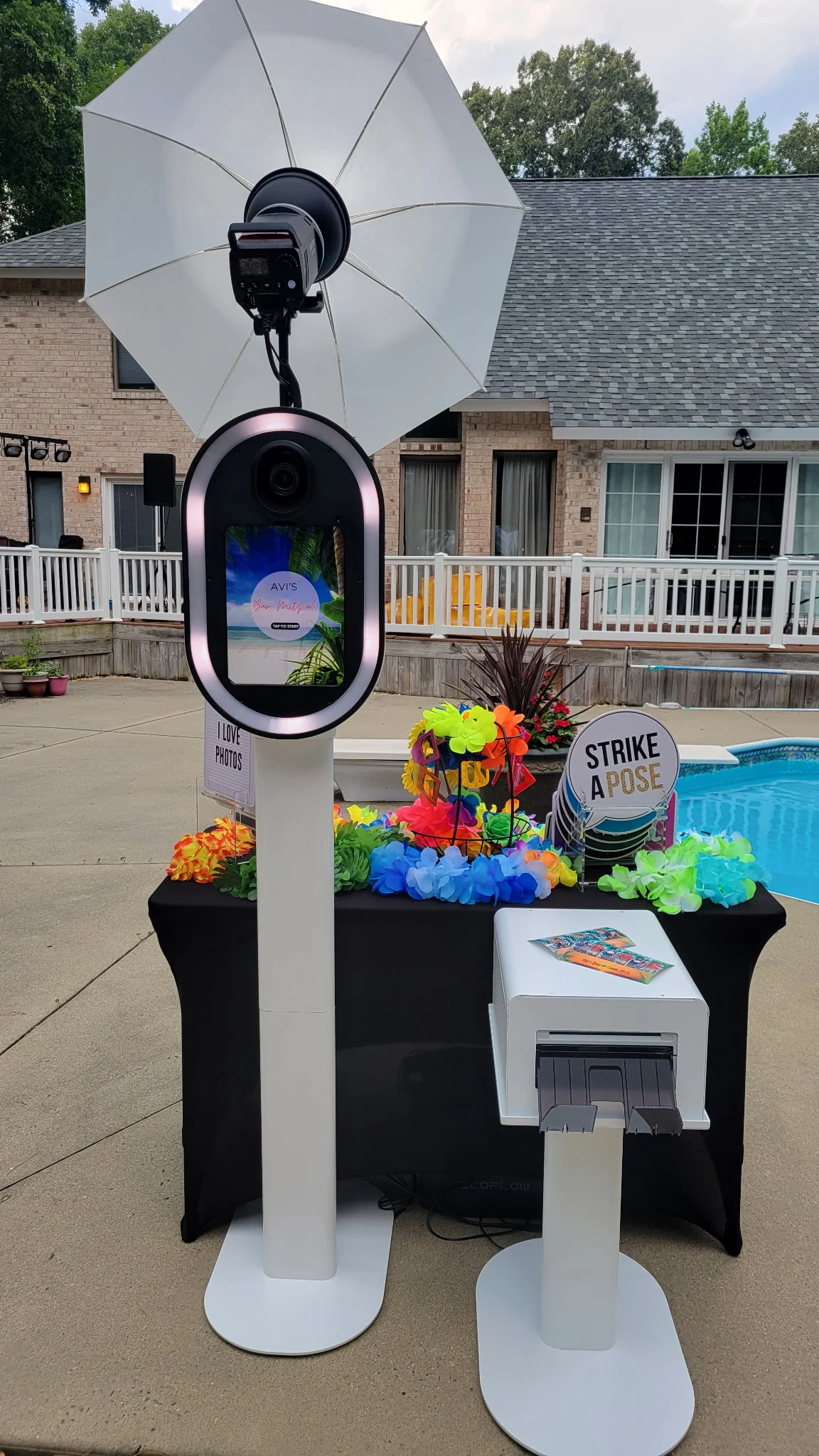Outdoor pool party photo booth setup Virginia Beach Hampton Roads — tropical props and Strike a Pose sign