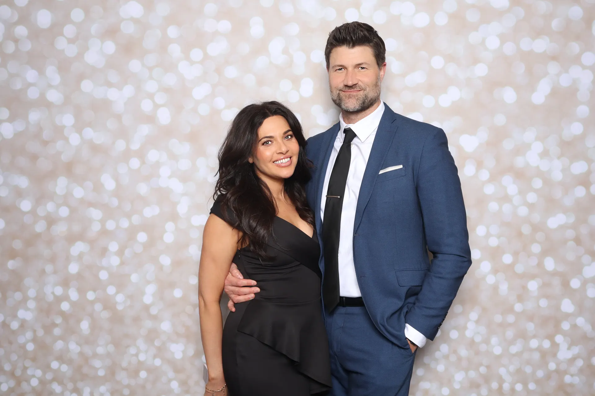 Couple at pre-wedding gala photo booth with champagne shimmer backdrop Virginia Beach