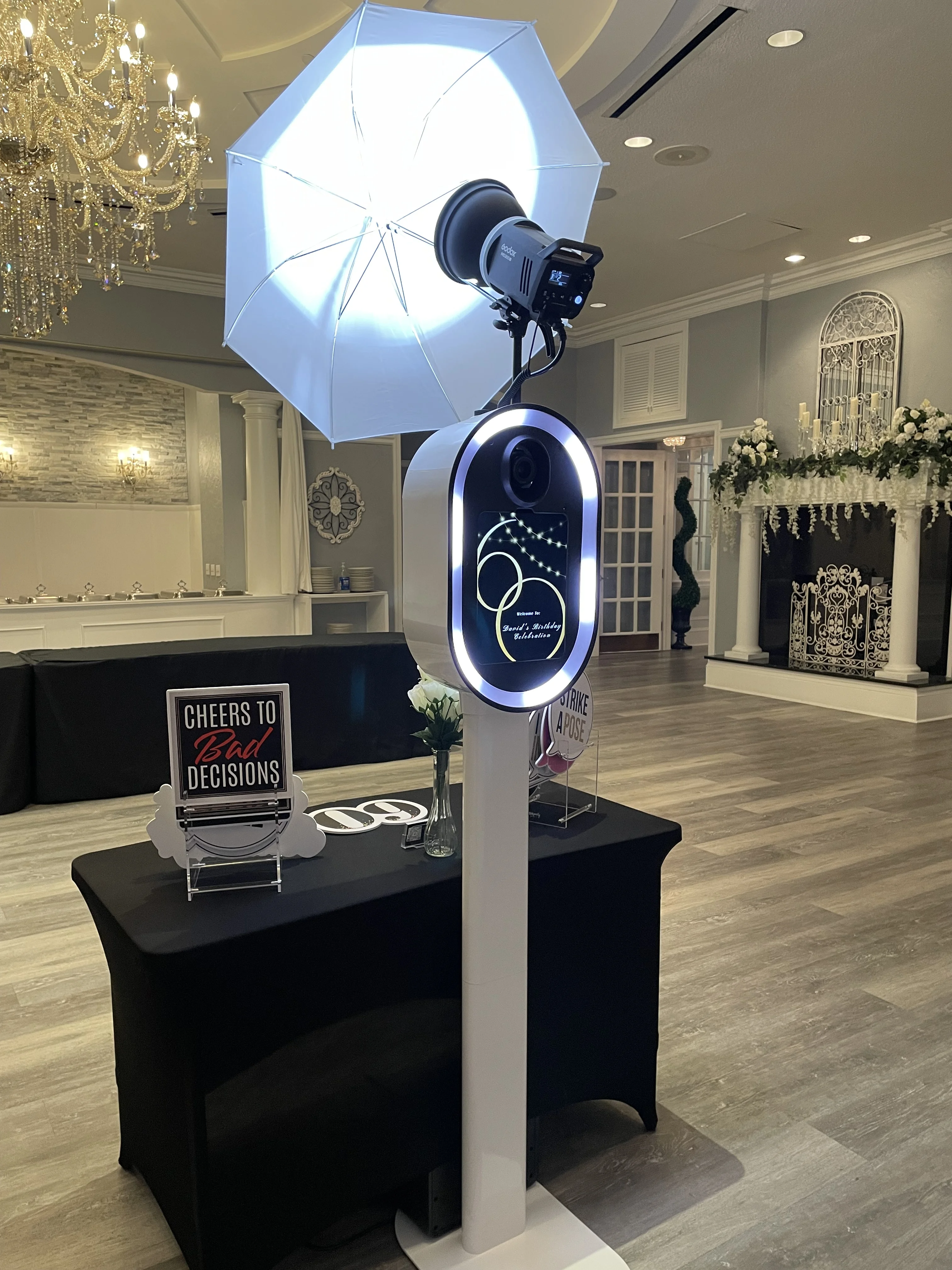 Wedding photo booth setup ring light chandelier ballroom Virginia Beach — elegant venue with Cheers to Decisions sign